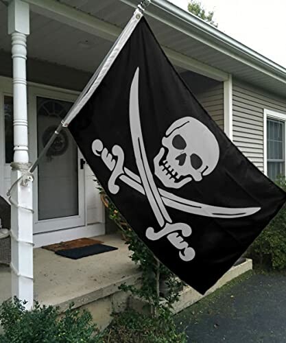 Pirate flag with skull and crossed swords hanging outside a house.